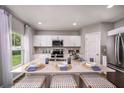 Bright kitchen features a central island with quartz countertops and seating at 1562 Sage Ave, Haines City, FL 33844