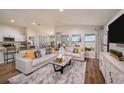 Bright living room with luxury vinyl flooring, large windows, and stylish neutral colored sofas at 1566 Sage Ave, Haines City, FL 33844
