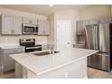 Modern kitchen featuring stainless steel appliances, center island, and sleek gray cabinetry at 1570 Sage Ave, Haines City, FL 33844