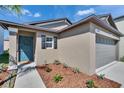 Charming single Gathering home with a teal front door and lush, manicured landscaping at 1792 Yellow Trl, Lakeland, FL 33801