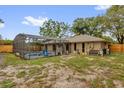 Exterior view of a home's backyard featuring a screened-in pool, patio, and fenced yard at 31632 Spruce Dr, Eustis, FL 32736