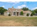 Sprawling single-story home showcasing neutral stucco, manicured landscaping, and an expansive front lawn at 32421 Wolfs Trl, Sorrento, FL 32776