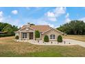 Inviting front exterior showcases a charming facade with manicured landscaping, stone accents, and a welcoming walkway at 32421 Wolfs Trl, Sorrento, FL 32776