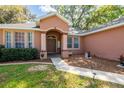 Inviting front entrance featuring a covered porch, walkway and decorative landscaping at 5416 Oxford Manor Cir, Lakeland, FL 33810