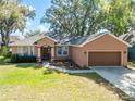 Charming one-story home featuring a well-manicured lawn and attached two-car garage at 5416 Oxford Manor Cir, Lakeland, FL 33810