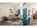 Bright living room with a cozy beige sectional, vibrant blue accents, and modern ceiling fan at 5416 Oxford Manor Cir, Lakeland, FL 33810