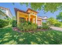 Beautiful home featuring a red front door, tan exterior, mature landscaping, and a tile roof at 8427 Prestbury Dr, Orlando, FL 32832