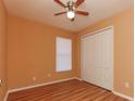 Cozy bedroom with wood floors, closet, ceiling fan, and a window that filters soft light at 316 Boca Ciega Rd, Mascotte, FL 34753