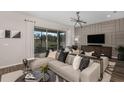 Inviting living room with neutral tones, sleek light fixture, and sliding glass doors opening to the outdoor patio at 1687 Ruby Ln, Lake Alfred, FL 33850