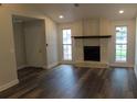 Spacious living room featuring wood-look floors, white brick fireplace, recessed lighting, and large windows at 3821 Whitedove Dr, Lakeland, FL 33812