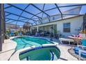Screened in pool with an attached spa, accompanied by patio furniture at 622 Copeland Dr, Haines City, FL 33844