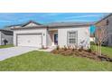 Inviting single-story home boasting a manicured lawn, two car garage, and traditional exterior at 13276 Tula Loop, Astatula, FL 34705