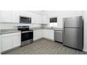 Modern kitchen featuring stainless steel appliances, white cabinets, and granite countertops at 13438 Leaping Water Way, Astatula, FL 34705