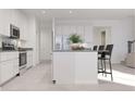 Bright kitchen featuring white cabinetry, stainless steel appliances, a functional island, and a seamless open layout at 254 Puma Loop, Groveland, FL 34736