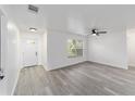 Bright, newly renovated living room showcasing neutral paint, modern flooring, ceiling fan, and lots of natural light at 39832 N Hibiscus Way, Lady Lake, FL 32159