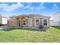 Charming single-story home featuring an attached two-car garage and a well-maintained lawn at 774 Lobelia Dr, Davenport, FL 33837