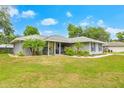 Inviting home with well-kept lawn, landscaping, and a cheerful yellow front door enhances curb appeal at 1007 Cr 463B, Lake Panasoffkee, FL 33538