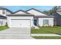 Beautiful single-story home with a two-car garage, blue door, and well-maintained front yard at 13442 Leaping Water Way, Astatula, FL 34705