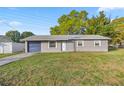 The exterior of a charming single story home with a blue garage door and well maintained lawn at 5728 Ne 21St Avenue Rd, Ocala, FL 34479