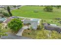 Aerial view of a home with a screened-in pool and a large, fenced backyard that backs up to a large open field at 4523 Oakglen Rd, Lakeland, FL 33813