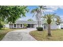 Charming single-story home featuring a circular driveway, attached garage, and well-maintained landscaping with palm trees at 4523 Oakglen Rd, Lakeland, FL 33813