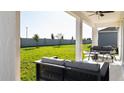 Covered patio with comfortable seating and a view of the expansive lawn at 1931 Rider Rain Ln, Apopka, FL 32703