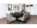 Elegant dining room with a modern table, stylish chairs, wood-look tile, and decorative mirrors at 258 Puma Loop, Groveland, FL 34736