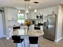 Well-lit kitchen featuring granite countertops, stainless appliances, and an island with breakfast bar seating at 620 San Pedro Dr, Lady Lake, FL 32159