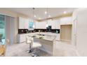Modern kitchen featuring white cabinets, stainless steel appliances, a center island with seating, and sliding glass doors at 3225 Armstrong Ave, Clermont, FL 34714