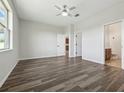 Open bedroom with wood floors, ceiling fan, and access to bathroom and kitchen areas at 1762 Regal River Cir, Ocoee, FL 34761