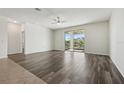 Bright, open living room with wood floors, modern ceiling fan, and sliding glass doors at 1762 Regal River Cir, Ocoee, FL 34761