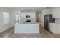 Bright kitchen with white cabinets, stainless steel appliances, and large center island at 9056 Wildlight Trl, Wildwood, FL 34785