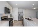 Modern kitchen with stainless steel appliances and white cabinetry at 9056 Wildlight Trl, Wildwood, FL 34785