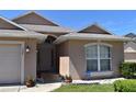 Inviting home exterior with manicured lawn, arched window, and security system visible at 1124 Liberty Hall Dr, Kissimmee, FL 34746