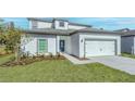 Charming home with a well-manicured lawn and a two-car garage, showcasing curb appeal at 13430 Leaping Water Way, Astatula, FL 34705