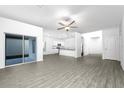 Spacious living area with modern gray wood-look flooring and a view into the bright kitchen at 13430 Leaping Water Way, Astatula, FL 34705