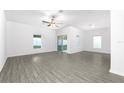 Bright living room featuring modern gray wood-look flooring, ample natural light and a ceiling fan at 13430 Leaping Water Way, Astatula, FL 34705