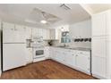 Bright kitchen featuring white cabinetry, modern appliances, granite countertops and wood flooring at 2971 Gardenia Dr, Indian Lake Estates, FL 33855
