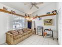 Cozy living room featuring tile floors, high ceilings, and natural light from a large window at 4524 Oak Arbor Cir, Orlando, FL 32802
