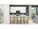 Modern kitchen featuring white cabinets, stainless steel appliances, and a center island with bar seating at 4578 Ochos Rios Pl, Kissimmee, FL 34758