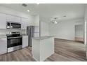 Open-concept kitchen featuring stainless steel appliances, granite countertops, and hardwood floors at 13283 Tula Loop, Astatula, FL 34705
