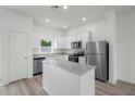 Modern kitchen with stainless steel appliances, granite counters and gray wood look floors at 13450 Leaping Water Way, Astatula, FL 34705
