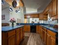 Spacious kitchen with wooden cabinetry, black appliances, and an island with seating at 4586 Cr 696, Webster, FL 33597