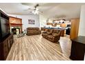 Open-concept living room and kitchen with wood floors, vaulted ceilings, and a stone fireplace at 4586 Cr 696, Webster, FL 33597