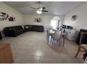 Spacious living room featuring tile floors, dark sofas, dining table, ceiling fan and large light-filled windows at 5835 Talavera St, Orlando, FL 32807