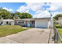 Brick home with a blue door, one-car garage, and a concrete driveway at 1043 Pineview Pl, Lakeland, FL 33801