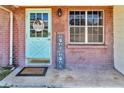 Close up of the front door featuring a blue door and brick surround at 1043 Pineview Pl, Lakeland, FL 33801