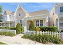 Inviting home with a well-manicured lawn, trimmed shrubs, and a white picket fence, showcasing charm and curb appeal at 1002 Periwinkle Ct, Celebration, FL 34747