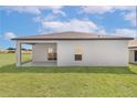 Expansive backyard featuring a covered patio, lush green grass, and serene views of the surrounding landscape at 1633 Nantucket Way, Winter Haven, FL 33884