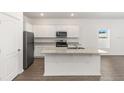 Modern kitchen featuring stainless steel appliances, granite countertops, and an eat-in island at 1645 Nantucket Way, Winter Haven, FL 33884